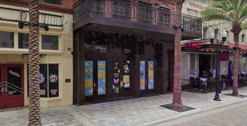 Colorful window decorations featuring cartoon characters and symbols on a storefront, surrounded by palm trees.