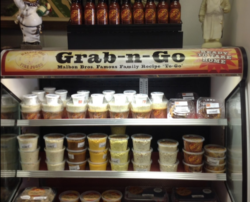 A display case labeled "Grab-n-Go" filled with various containers of prepared foods and sauces.