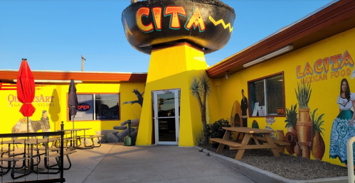 Colorful exterior of La Cita Mexican Food restaurant, featuring vibrant murals and outdoor seating.