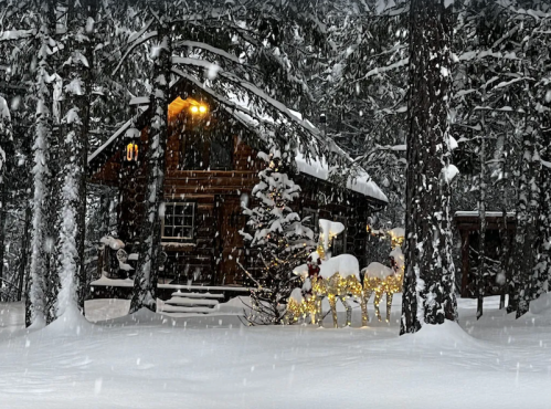 A cozy cabin in a snowy forest, illuminated by warm lights, with decorative reindeer in the foreground. Snowflakes are falling.