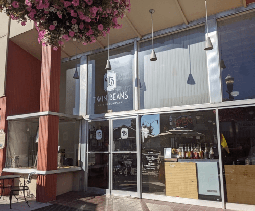 Exterior of Twin Beans Coffee Company, featuring large windows and a welcoming entrance with outdoor seating.