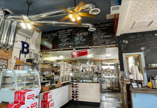 A cozy café interior with a menu board, display cases, and rustic decor, featuring a welcoming atmosphere.