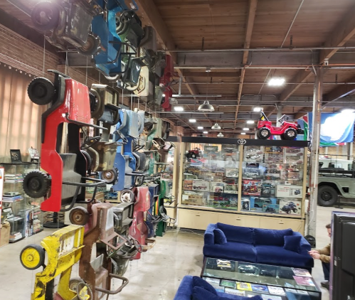 A vintage toy car display hangs in a spacious room filled with memorabilia and a blue couch.