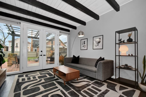 Cozy living room with a gray sofa, wooden coffee table, and large glass doors leading to an outdoor space.