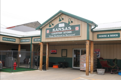 Exterior of Kansas Country Store featuring a sign, open entrance, and sections for livestock, clothing, and pet supplies.