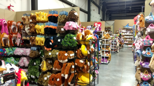 A colorful aisle filled with various plush toys and stuffed animals on display in a store.