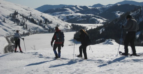 Several individuals snowshoe in heavy snow in a winter day in Washington.