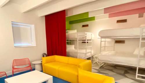 Brightly colored room with bunk beds, a yellow couch, and red curtains, featuring modern decor and playful design.