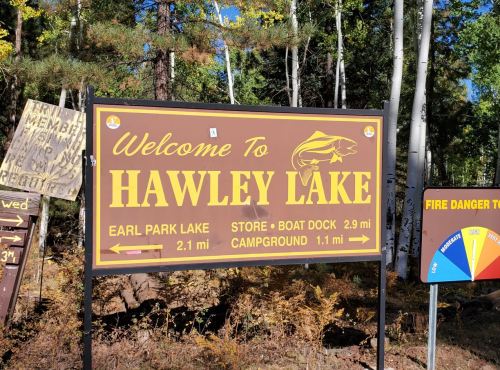 Sign welcoming visitors to Hawley Lake, with distances to Earl Park Lake, store, boat dock, and campground.