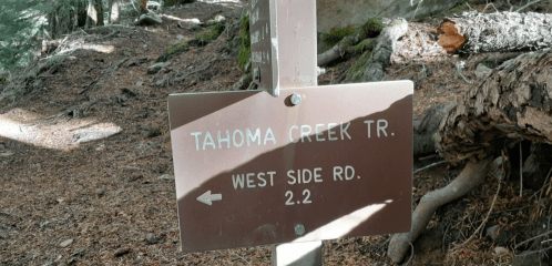 Trail sign for Tahoma Creek Trail, indicating West Side Road, 2.2 miles to the left.
