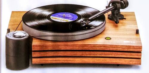A wooden turntable with a vinyl record spinning, featuring a sleek design and a tonearm.