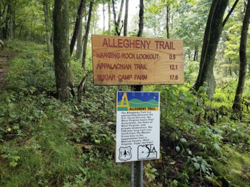 Wooden signpost for the Allegheny Trail, listing distances to Hanging Rock Lookout, Appalachian Trail, and Sugar Camp Farm.