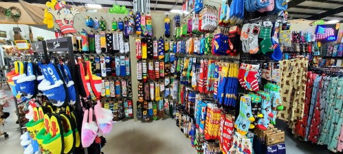 A colorful display of various socks hanging on racks in a store, featuring fun patterns and designs.