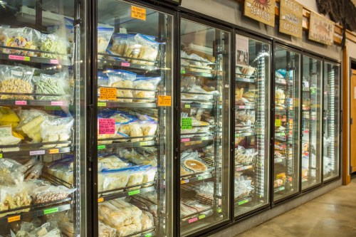 A well-stocked freezer display filled with various packaged foods and ingredients in clear bags.