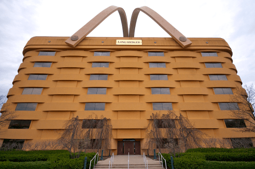 A large, whimsical building designed to resemble a basket, featuring a golden exterior and prominent handles.