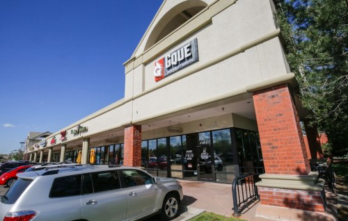 Exterior view of a retail building with a sign for "Gove," featuring a parking lot and clear blue sky.