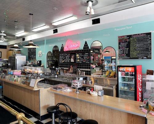 A retro-style diner interior with a counter, colorful walls, and a menu board displaying various food items.