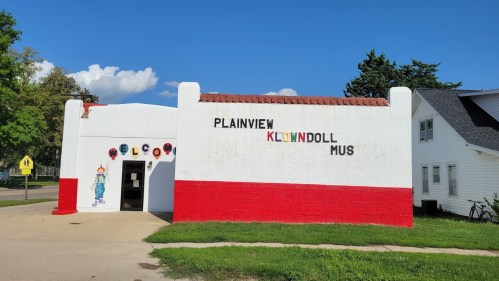 A colorful building with "Plainview Klondoll Museum" painted on the wall, featuring a clown illustration and a red base.