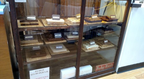 A display case filled with various fudge flavors, labeled and priced at $11.99 per pound.
