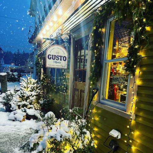 A cozy restaurant entrance adorned with festive lights and snow, creating a warm winter atmosphere.
