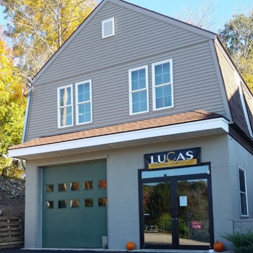 A two-story building with a gray exterior, large windows, and a sign that reads "LUCAS Engineering Company LLC."