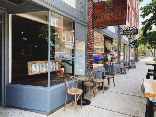 A cozy café exterior with outdoor seating, featuring an "OPEN" sign and a welcoming atmosphere.