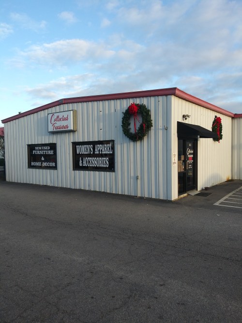 Exterior of a store named "Collected Treasures," featuring wreaths and signs for furniture and women's apparel.