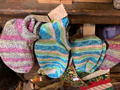 Colorful striped socks in pastel shades displayed on a wooden surface, with tags attached.