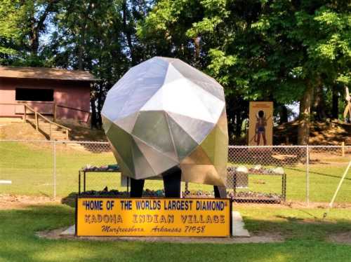 A large, metallic diamond sculpture with a sign reading "Home of the World's Largest Diamond" at Kadona Indian Village.