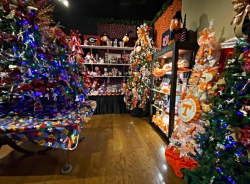 A festive room filled with decorated Christmas trees, team merchandise, and colorful holiday displays.