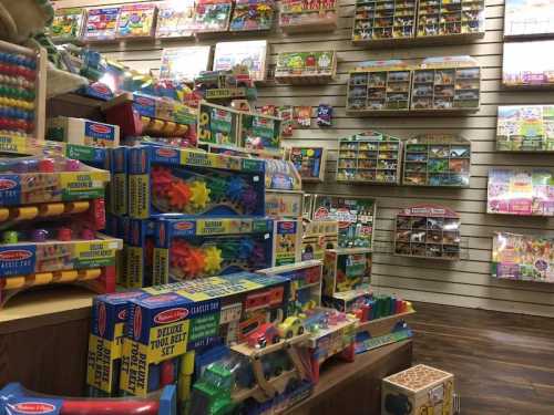 A colorful toy store display filled with various educational toys and games on shelves and tables.