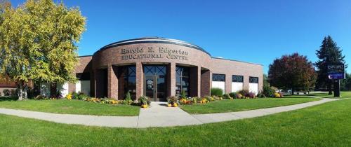 Exterior view of the Harold E. Engleton Educational Center, featuring a landscaped lawn and clear blue sky.