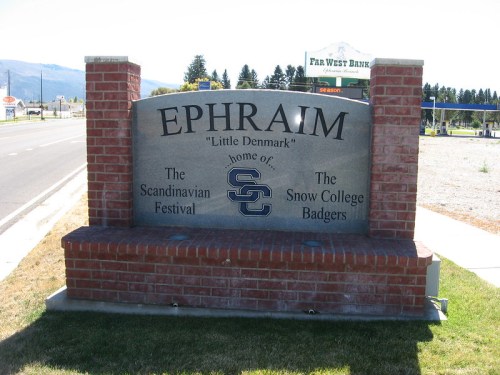 Sign for Ephraim, Utah, highlighting the Scandinavian Festival and Snow College Badgers, with a brick base.
