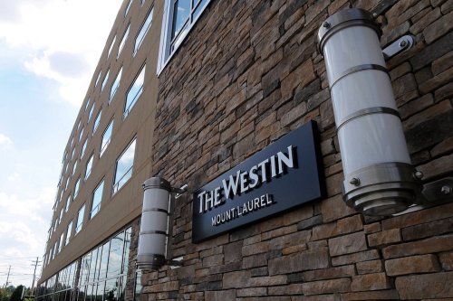 Exterior view of The Westin hotel in Mount Laurel, featuring a stone facade and modern lighting fixtures.