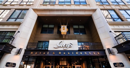 Entrance of a hotel with a sign reading "Jhey's Hotel & Residences" and modern architectural design.
