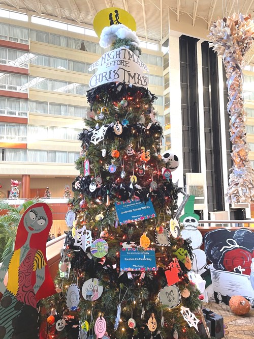 A decorated Christmas tree themed around "The Nightmare Before Christmas," featuring colorful ornaments and lights.
