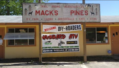 Signage for Mack's Pines, featuring RV park, cabins, and a welcome banner for off-roaders and ATV services.
