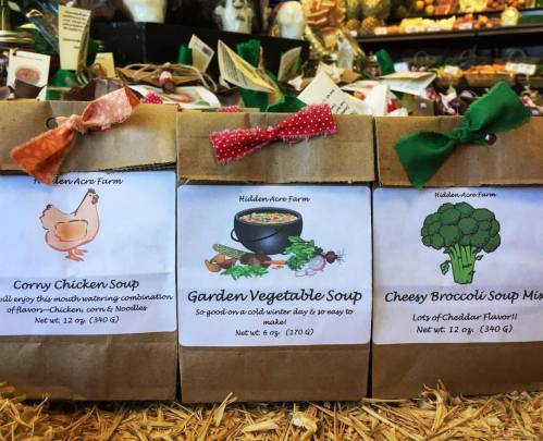 Three soup mix packages labeled "Corny Chicken Soup," "Garden Vegetable Soup," and "Cheesy Broccoli Soup" on display.