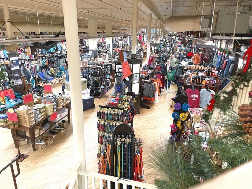 A spacious retail store filled with various clothing and outdoor gear, organized on shelves and displays.
