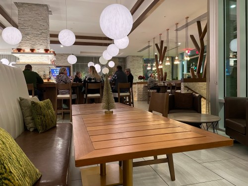 A cozy restaurant interior with wooden tables, soft lighting, and patrons enjoying their meals in the background.