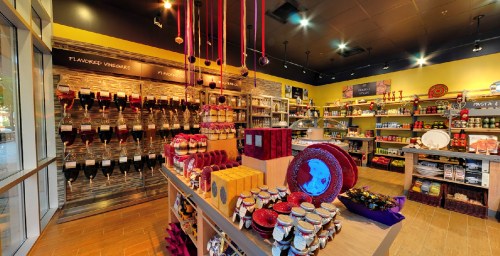 A colorful store interior showcasing shelves of gourmet products, jars, and decorative items on display.