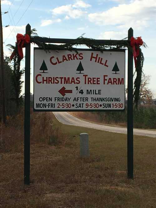 Sign for Clarks Hill Christmas Tree Farm, indicating it's 1/4 mile ahead, with holiday decorations and hours of operation.