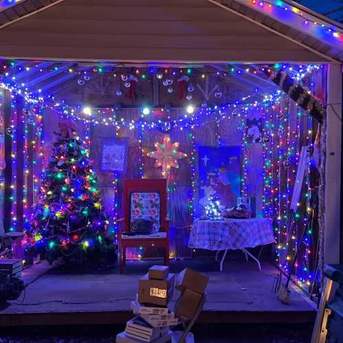 A cozy porch decorated with colorful holiday lights, a Christmas tree, and festive decorations.