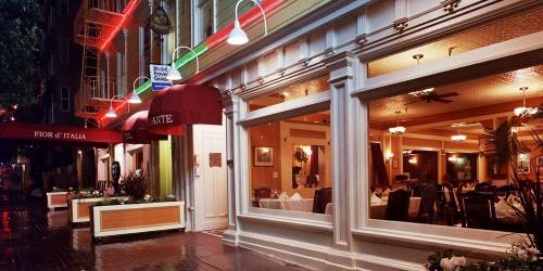 A cozy restaurant exterior with red awnings, warm lighting, and a welcoming atmosphere on a rainy evening.