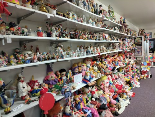 A colorful display of various dolls and toys arranged on shelves in a room, showcasing a wide variety of characters and styles.