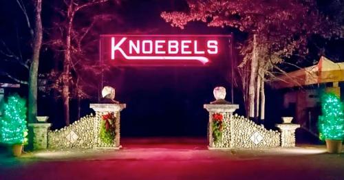Brightly lit entrance to Knoebels amusement park, featuring festive decorations and a glowing sign.