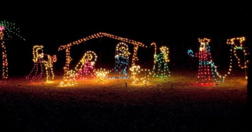 A festive display of colorful lights depicting a nativity scene at night.