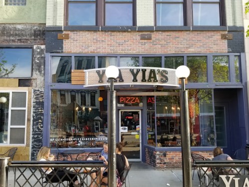 Exterior of Yia's Pizza restaurant with outdoor seating and a welcoming entrance.