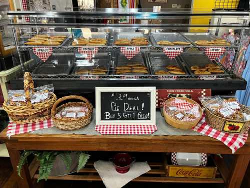 Display case filled with various baked goods, with a sign promoting a pie deal: "Buy 5, get 1 free."