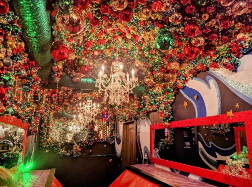 A vibrant room decorated with colorful ornaments and a chandelier, featuring a festive, whimsical atmosphere.